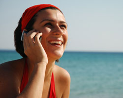 Une femme au téléphone portable à la plage