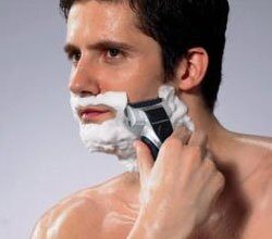 Homme utilisant un rasoir électrique avec de la crème à raser