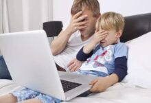 Un homme et un enfant cachent leurs yeux devant l'ordinateur