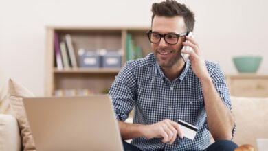 Un homme qui fait des opérations bancaires par téléphone
