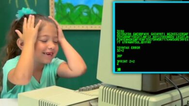 Une jeune fille réagit à un vieil ordinateur monochrome